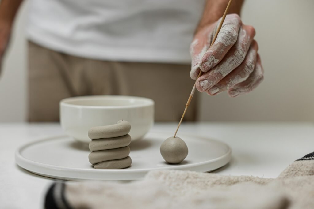 Close-up of person crafting with clay, showcasing creative handwork and craftsmanship.